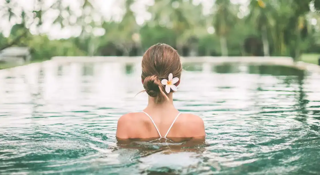 Mujer de espaldas dentro del agua de una piscina