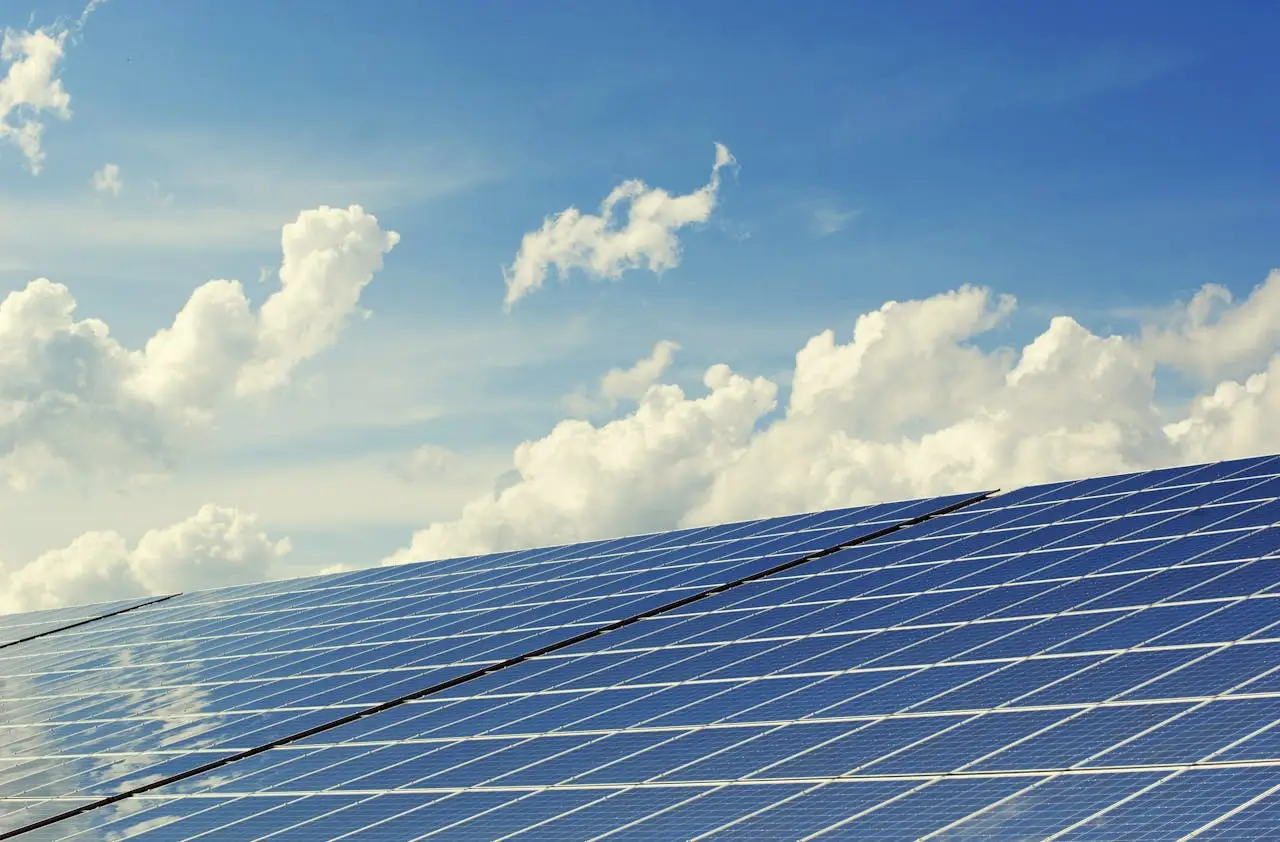 Placas solares fotovoltaicas bajo un cielo con nubes