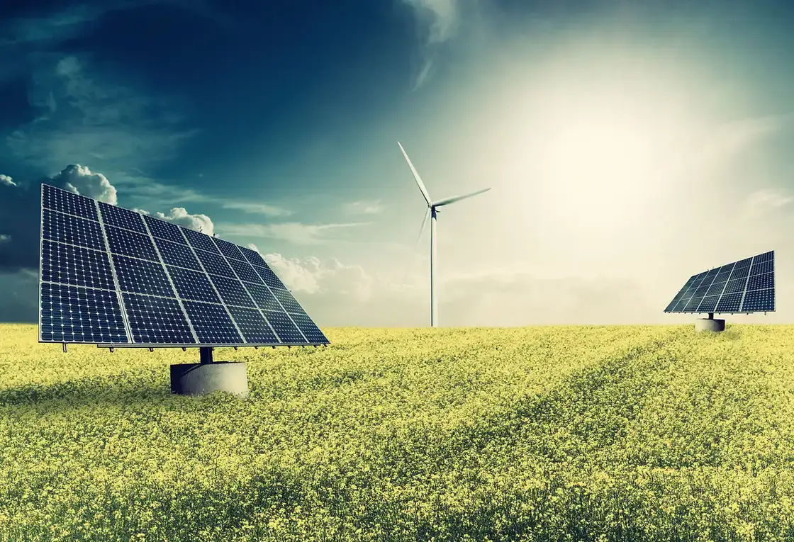 Placas solares fotovoltaicas y un aerogenerador en un campo verde