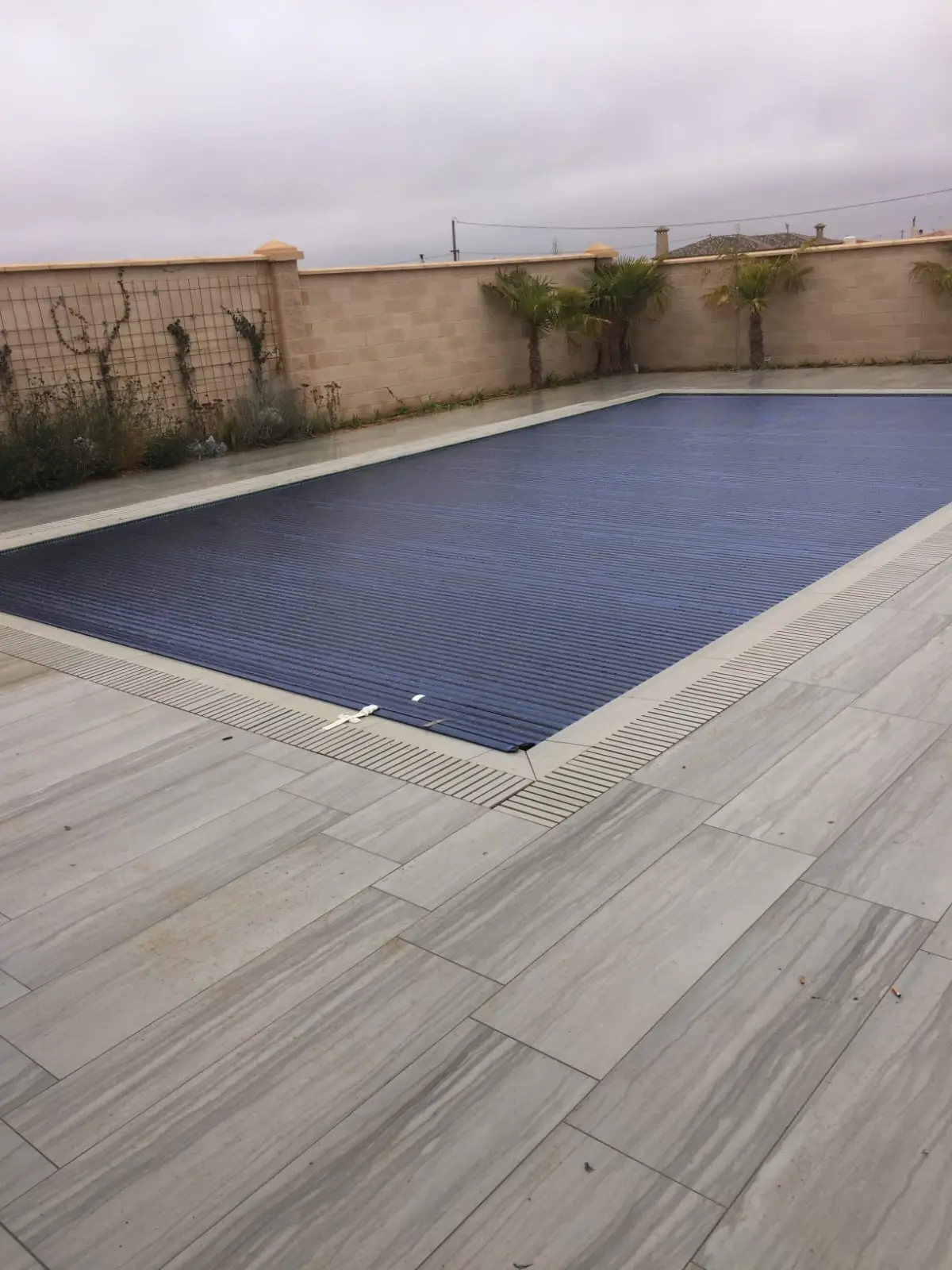 Piscina con el cobertor de lamas extendido sobre el agua