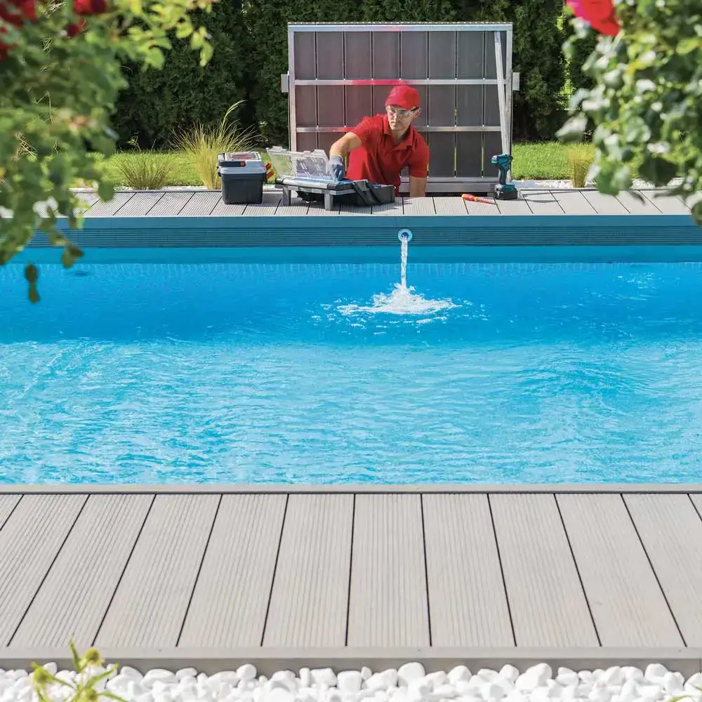 Piscina con un chorro de agua en el centro y un técnico trabajando al fondo