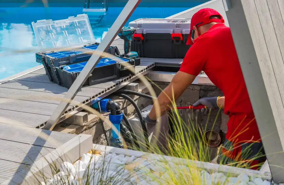 Técnico revisando el equipo de una piscina junto a su caja de herramientas